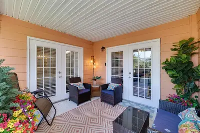 a screened in porch with chairs and a table at 5 Mi to WDW Resort-Style Condo with Pool Access in Kissimmee