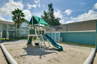 a playground with a slide in front of a building at 5 Mi to WDW Resort-Style Condo with Pool Access in Kissimmee