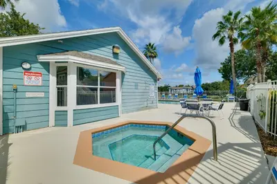 a house with a swimming pool next to a building at 5 Mi to WDW Resort-Style Condo with Pool Access in Kissimmee