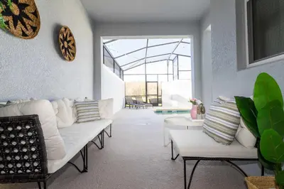 a living room with white furniture and a large window at Stylish & Fun Retreat Pool Themed Rooms in Kissimmee