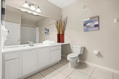 a bathroom with a sink and a toilet and a mirror at 3 Bedrooms 2 Bathrooms Vista Cay 4814-405 Ca in Orlando