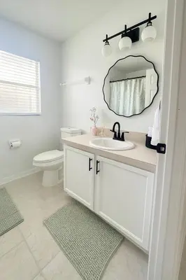 a white bathroom with a sink and a mirror at Once upon a good stay - 7 Beds Pool Home by Disney in Kissimmee