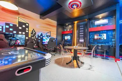 a room with a ping pong table and a video game at 12BR Home w Game Room Movie Theater in Kissimmee