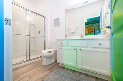 a bathroom with a toilet and a shower and a sink at 12BR Home w Game Room Movie Theater in Kissimmee