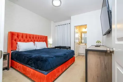 a bedroom with a large bed with a red headboard at 12BR Home w Game Room Movie Theater in Kissimmee