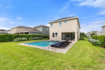 a backyard with a swimming pool and a house at Sunset Games Retreat at Reunion Resort villa in Orlando