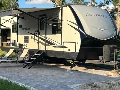 an rv parked next to a table and chairs at Beautiful RV 15 Min to Downtown Orlando in Orlando