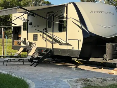 an rv parked next to a patio with a picnic table at Beautiful RV 15 Min to Downtown Orlando in Orlando