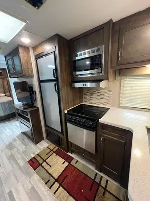 a kitchen with a stove and a microwave at Beautiful RV 15 Min to Downtown Orlando in Orlando