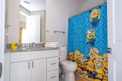 a bathroom with a toilet and a blue shower curtain at New Vacay Home 5BD 5BA - 5 miles to Disney in Orlando