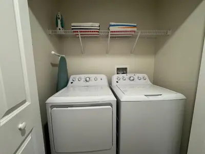 a small laundry room with a washer and dryer at 4BR-3BA Townhouse with Private Pool in Storey Lake in Kissimmee