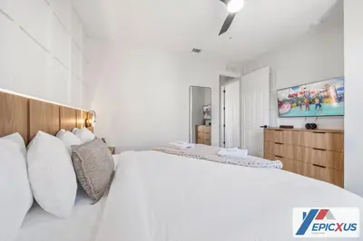 a white bedroom with a large bed with white pillows at The Epic New Jersey Vista Cay in Orlando