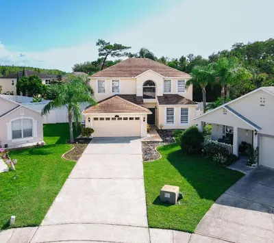 a house with a yard with a driveway at Serenity in the sun in Kissimmee
