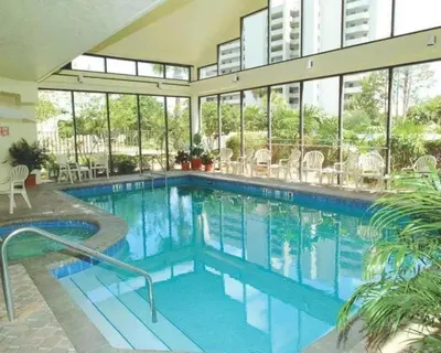 a swimming pool with blue water in a building at Apartamento Moderno 2 Quartos no Enclave in Orlando