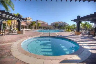 a large swimming pool in a resort with a patio at Townhouse 3 suítes no Vista Cay Resort in Orlando