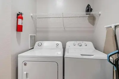 a small laundry room with a washer and dryer at Apartamento moderno 3 quartos no Vista Cay in Orlando