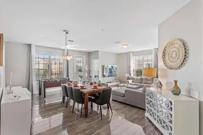 a dining room and living room with a table and chairs at Apartamento moderno 3 quartos no Vista Cay in Orlando