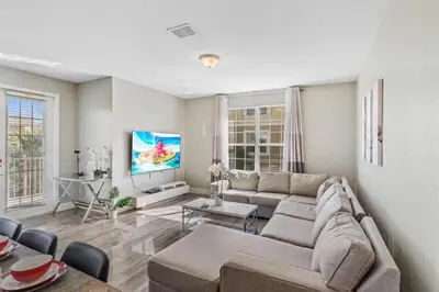 a living room with a couch and a tv at Apartamento moderno 3 quartos no Vista Cay in Orlando