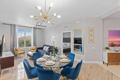 a dining room and living room with a table and chairs at Moderno apê 3 quartos no Vista Cay – Perto Disney in Orlando
