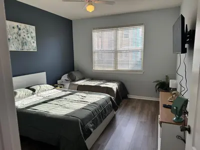 a bedroom with two beds and a flat screen tv at Bellavue Getaway in Kissimmee