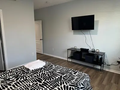 a bedroom with a black and white bed and a flat screen tv at Bellavue Getaway in Kissimmee