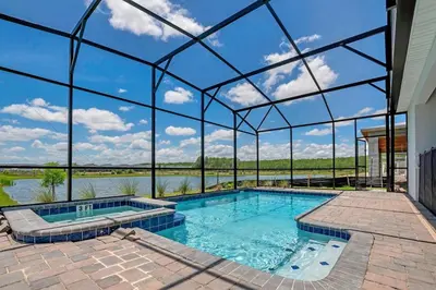 a large swimming pool with a clear glass house at Last Minute Disney Private Pool Hot Tub Game Room Themed Bedrooms. Book Now SLR551 in Kissimmee