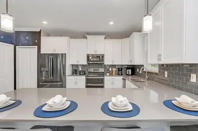 a kitchen with white cabinets and a table with hats on it at Last Minute Disney Private Pool Hot Tub Game Room Themed Bedrooms. Book Now SLR551 in Kissimmee