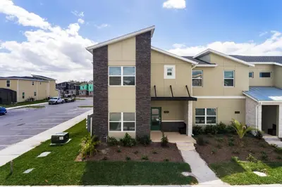 a apartment building with a parking lot at Last Minute Disney Luxury Townhouse with Private Pool. Book Now SLR557 in Kissimmee