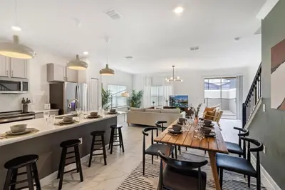 a kitchen and living room with a table and chairs at Last Minute Disney Luxury Townhouse with Private Pool. Book Now SLR557 in Kissimmee