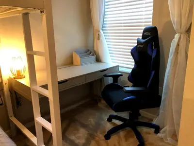 a bedroom with a desk and a chair next to a bunk bed at NEW Home 3 Bedrooms Water View Disney Universal in Kissimmee