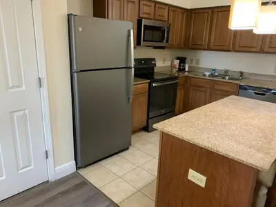 a kitchen with a stainless steel refrigerator and wooden cabinets at Near Orlando Convention center and all Park's in Orlando