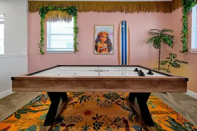 a bath tub in a pink room with a surfboard at Family Escape | Moana Vibes | Pool + Games in Orlando