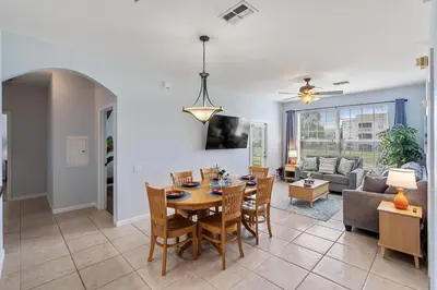 a dining room and living room with a table and chairs at 2302 Butterfly Palm 102 in Kissimmee
