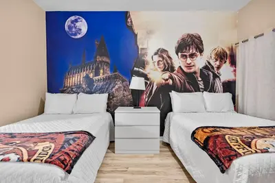 a bedroom with two beds and a movie poster at Cozy Themed 04 bedrooms - Close to Disney in Kissimmee