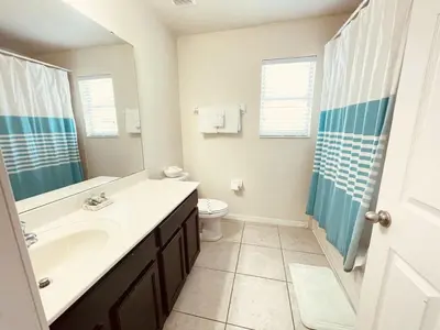 a bathroom with a sink and a toilet and a shower at 4 Bed Private Yard-Pool Home in Kissimmee