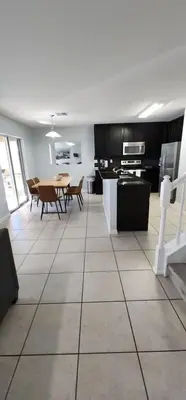 a kitchen and dining room with a table and chairs at 4 Bed Private Yard-Pool Home in Kissimmee