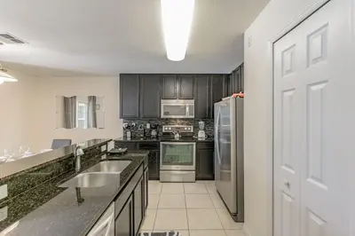 a kitchen with a sink and a refrigerator at 4 Bed Private Yard-Pool Home in Kissimmee