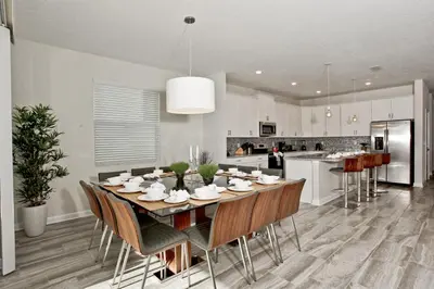 a dining room and kitchen with a table and chairs at Private Heated Pool Water View Resort Fun Near Disney in Kissimmee