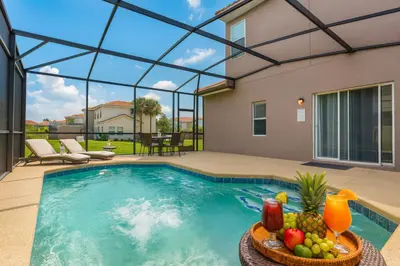 a swimming pool with a bowl of fruit on a table at Plunge Pool Oasis Bella Vida Resort Close to Parks in Kissimmee
