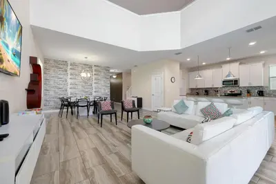 a living room with a white couch and a dining room at Family Pool Villa I Near Disney I 2 Free Clubhouses in Kissimmee