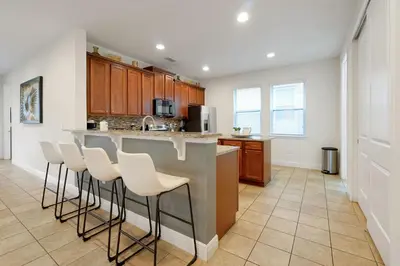 a kitchen with a counter and bar stools at Magical Getaway Near Disney I Pool and Fun Room in Orlando
