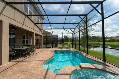 a patio with a pool and a table and chairs at Casa Familiar c/ Piscina 9 Quartos Perto Disney in Kissimmee