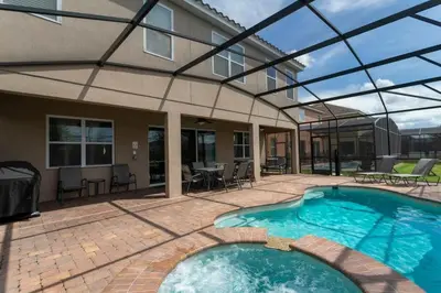 a swimming pool with a glass roof on a house at Casa Familiar c/ Piscina 9 Quartos Perto Disney in Kissimmee