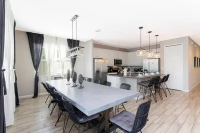 a dining room and kitchen with a table and chairs at Casa Familiar c/ Piscina 9 Quartos Perto Disney in Kissimmee