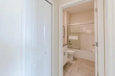 a white bathroom with a toilet and a tub at 2807 - Storybook Escape in Kissimmee