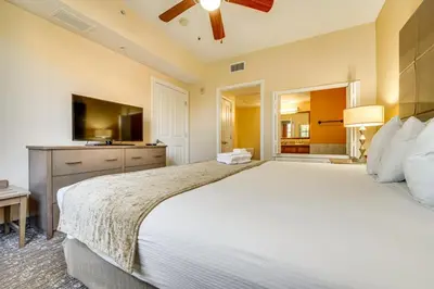 a bedroom with a large white bed and a television at Floridays Resort Condo 11 Mi to Walt Disney World! in Orlando