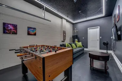 a room with a foosball table and a couch at NEW, Disney,10mi, Themed Rooms, PvtPool, Movie, Game Room in Kissimmee