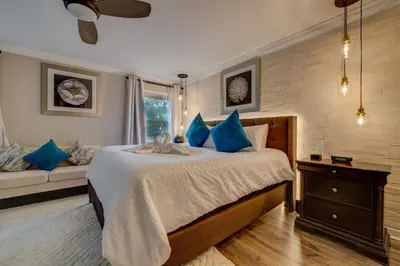 a bedroom with a bed with blue pillows and a couch at NEW, Disney,10mi, Themed Rooms, PvtPool, Movie, Game Room in Kissimmee