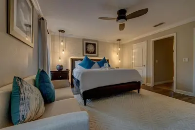 a bedroom with a bed with blue pillows and a couch at NEW, Disney,10mi, Themed Rooms, PvtPool, Movie, Game Room in Kissimmee