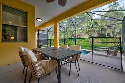 a dining room with a table and chairs on a balcony at NEW, Disney,10mi, Themed Rooms, PvtPool, Movie, Game Room in Kissimmee